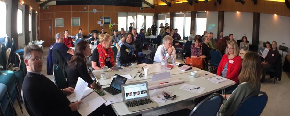 lots of people sat at tables at a workshop event