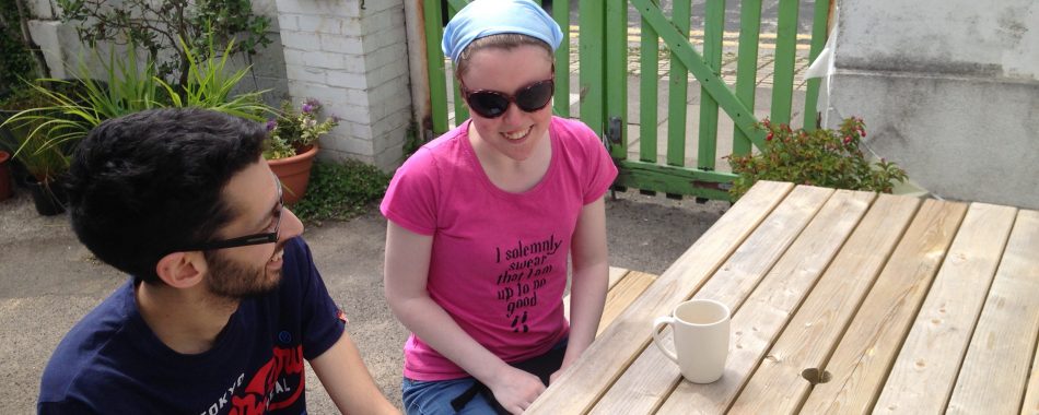 Two young people outside at a table