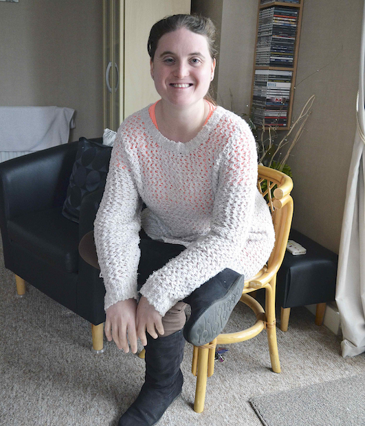 Young woman sitting in chair at home.